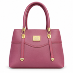 A structured magenta leather handbag with gold-tone hardware, featuring dual top handles, a front strap detail, and a gold brand plaque on a white background.